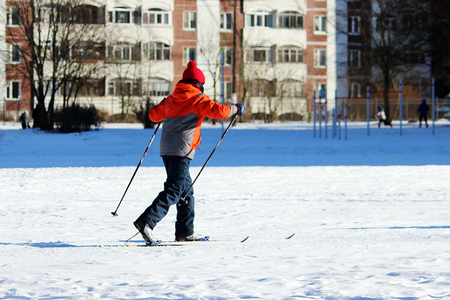 child goes skiing on the inner court of the school during physical education classes.の写真素材