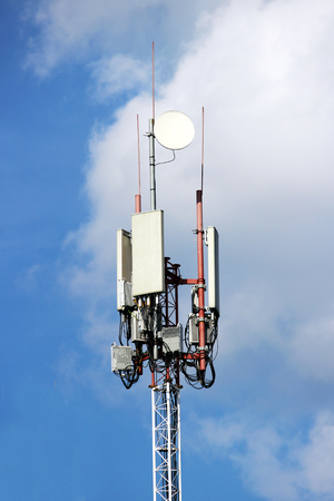 satellite dishes and plates on the spire of the tower for telecommunications and the Internet against the skyの写真素材