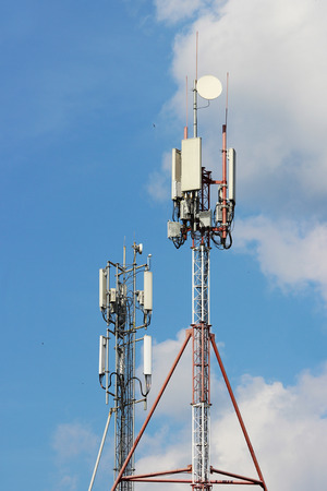 satellite dishes and plates on the spire of the tower for telecommunications and the Internet against the skyの写真素材