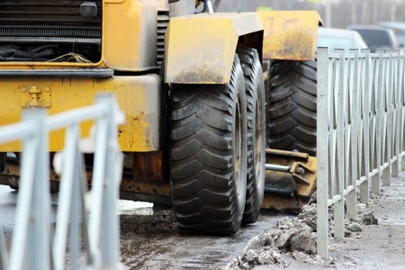 tractor cleans the road in the city of dirty snow.の写真素材