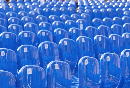 A lot of blue plastic numbered chairs stand in rowsの写真素材