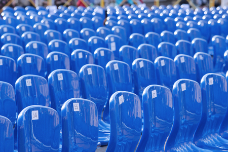 A lot of blue plastic numbered chairs stand in rowsの写真素材