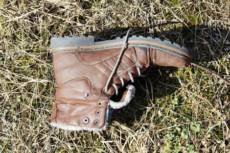 Old lone brown shoe lies on a damp groundの写真素材
