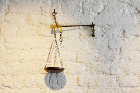 The old metal scales decorate the white wall.の写真素材