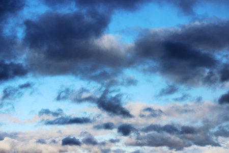 Huge white cumulus clouds against blue sky in spring