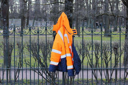 Working blue-orange warm jacket hanging on the fenceの写真素材