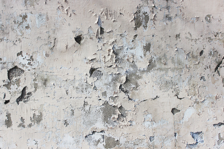 old beige wall with peeling plaster for background.の写真素材