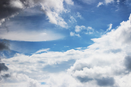 Huge white cumulus clouds against blue sky in spring before the rain in the form of a lumen or frameの写真素材