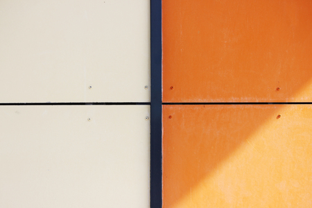 The wall of the house, trimmed with colorful panels, painted in bright colors. Orange and beige.の写真素材