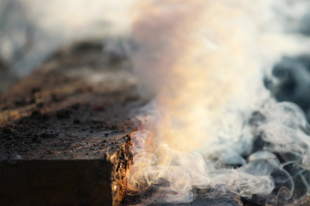 White smoke from the fire where wet boards and sawdust lie.の写真素材