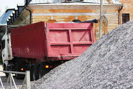 A working truck is preparing to unload gravel on the site to build a parking lot for tourist buses. The upper awning is rolled up.の写真素材