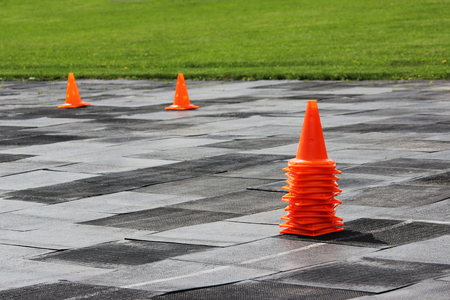 Plastic orange signal cones stand at the stadium in preparation for the competition for lifting weights.の写真素材