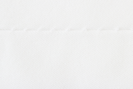 Macro texture of light beige fabric with machine seam.の写真素材
