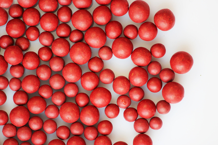 Macro photo of many red ball-shaped pills. Tibetan folk medicine from the herbal complex.の写真素材