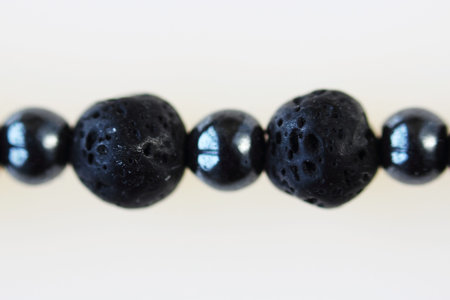 Necklace from black vesuvian and hematite. Macro shot on white backgroundの写真素材