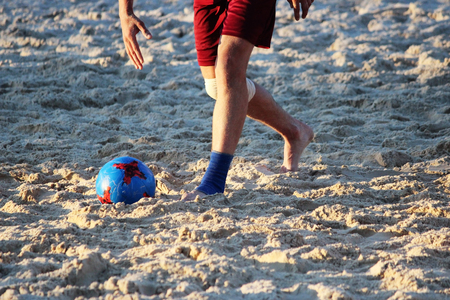 Young men play football in the summer on the sand platform.の写真素材