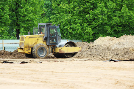 compactor is compacting the surface of the earth. Construction of the city stadium