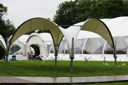 Festival white big tents and arbor are set for the festive reception in the park on holidayの写真素材
