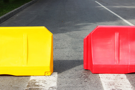 Red and yellow plastic barriers blocking the roadの写真素材