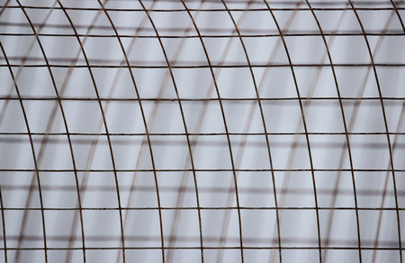 The bent sheet of metal iron reinforcement against the background of beige sidingの写真素材