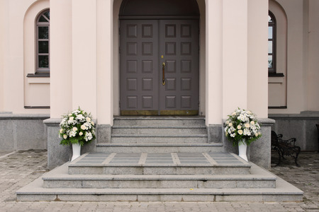 A floral bouquet of cream roses and chrysanthemums at the entrance to the church as a decoration of the holiday. Professional floristicsの写真素材