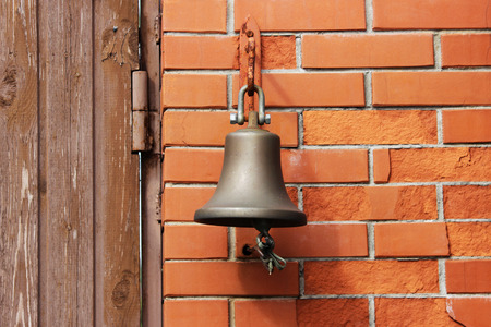 A large bell next to the door, replacing the doorbell. the bell Welcome. Ring the bell.の写真素材