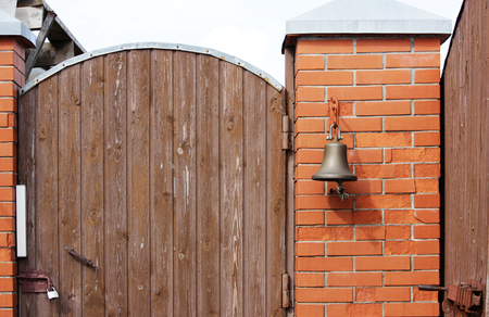 A large bell next to the door, replacing the doorbell. the bell Welcome. Ring the bell.の写真素材