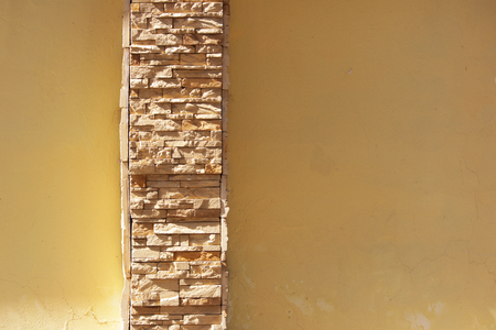 beige plastered wall with an insert of natural limestone of the same color.の写真素材