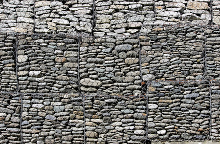 reinforcement of the embankment with the help of a gabion - a galvanized metal wire filled with crushed stone.の写真素材