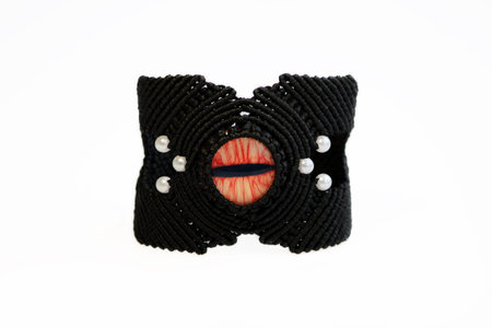 black bracelet for the hand from waxed thread, and red dragon eye in the technique of macrame on a...