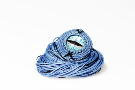 blue bracelet for the hand from waxed thread, and blue dragon eye in the technique of macrame in the manufacturing process on a white backgroundの写真素材