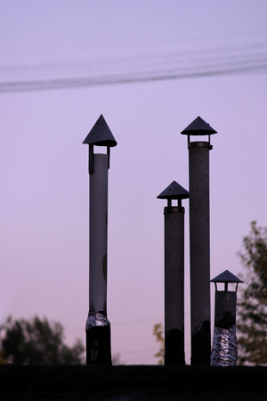 four silhouette pipes on the roof of the garages. vertical imageの写真素材
