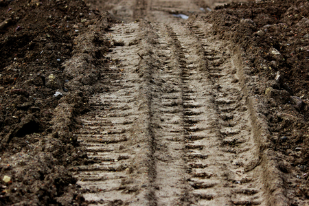 Wheel tracks in the mud, detail footprints bulldozer in the construction road.の写真素材
