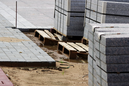 many curbs for construction works on pallets at the site laying paving slabs city square.の写真素材
