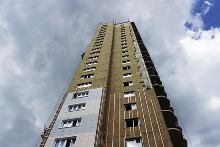 newly built high-rise building with insulating ecological modern panels on a blue sky background.の写真素材