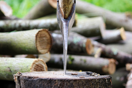 A sharp blade of an ax that sticks out in a wooden chock. rustic concept.の写真素材