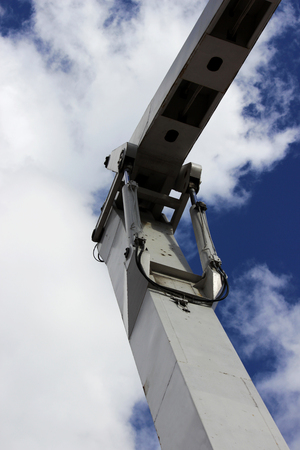 metal steel hydraulic piston to working excavator on a blue sky background.の写真素材