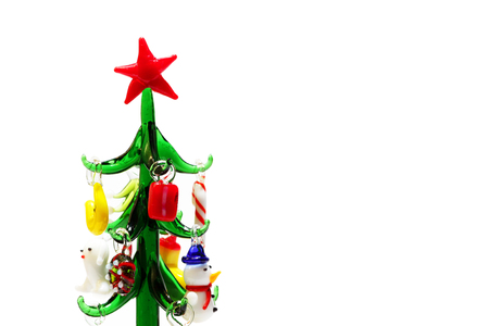 Christmas glass small herringbone with miniature colorful toys. New Year's souvenir on a white background. Festive postcard.の写真素材