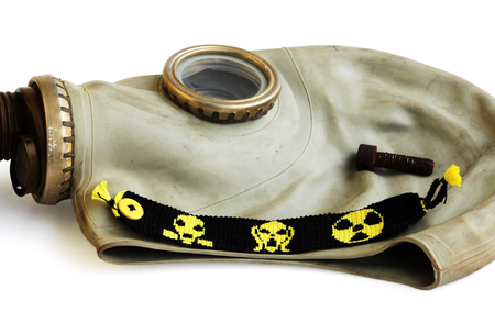 trophies of the stalker: old Russian gas mask, rusty nail and yellow-black baubles on a white backgroundの写真素材