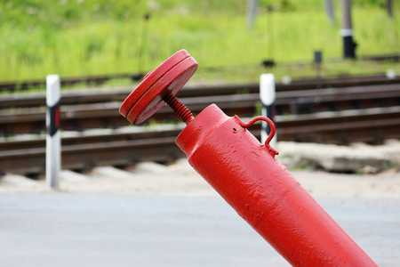 Railway crossing, anti-RAM devices. Red crossing fence device that automatically lifts plates on the road, prohibiting the passage of cars when the train approaches.の写真素材