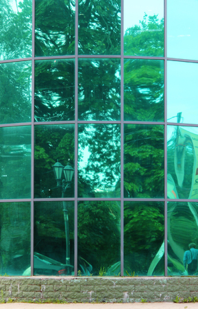 Large green glass windows in the city shopping center.の写真素材