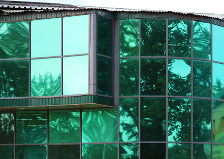 Large green glass windows in the city shopping center.の写真素材