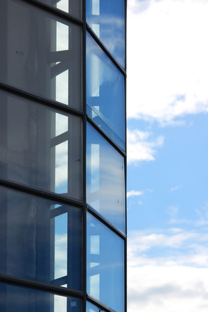 Large blue glass windows in the city shopping center and sky.の写真素材