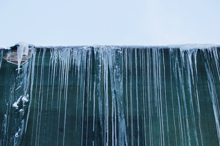 Restoration of the building and a protective green building mesh with frozen water that drained from the roof.の写真素材