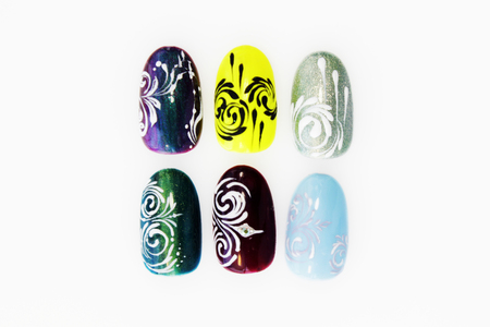 many plastic pink tips for nail extension and training in applying design while training a manicure. trial student work in the form of monograms, flowers and animals, with pasted pastes on a white backgroundの写真素材