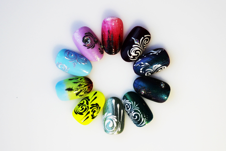 many plastic pink tips for nail extension and training in applying design while training a manicure. trial student work in the form of monograms, flowers and animals, with pasted pastes on a white backgroundの写真素材