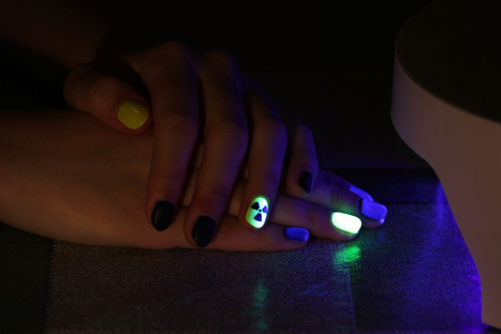 the original manicure in the form of a radioactive danger sign with gel shellac varnish, glows in the dark with ultraviolet lightの写真素材