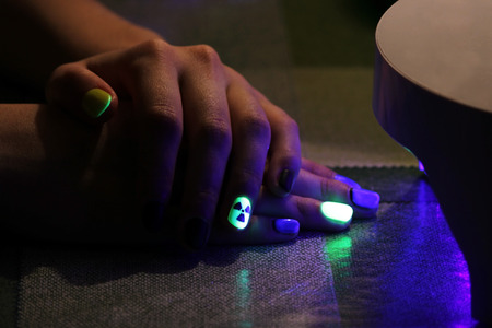 the original manicure in the form of a radioactive danger sign with gel shellac varnish, glows in the dark with ultraviolet lightの写真素材