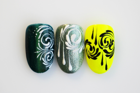 three plastic tips for nail extension and training in applying design while training a manicure on a white background. trial student work in the form of monogramsの写真素材