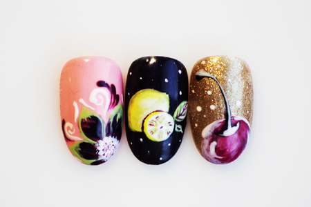 three plastic tips for nail extension and training in applying design while training a manicure on a white background. trial student work in the form of flower, lemon, cherryの写真素材